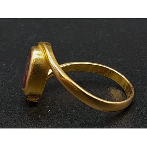 79 - A 22K Yellow Gold Red Stone Crossover Ring. Size Q. 4.87g total weight. A/F. Ref - 8667.