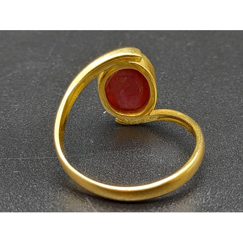 79 - A 22K Yellow Gold Red Stone Crossover Ring. Size Q. 4.87g total weight. A/F. Ref - 8667.