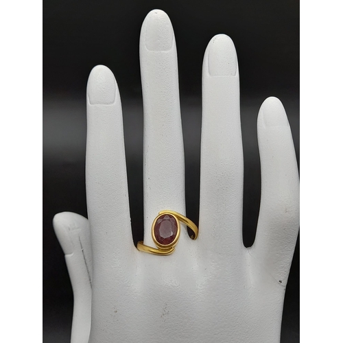 79 - A 22K Yellow Gold Red Stone Crossover Ring. Size Q. 4.87g total weight. A/F. Ref - 8667.