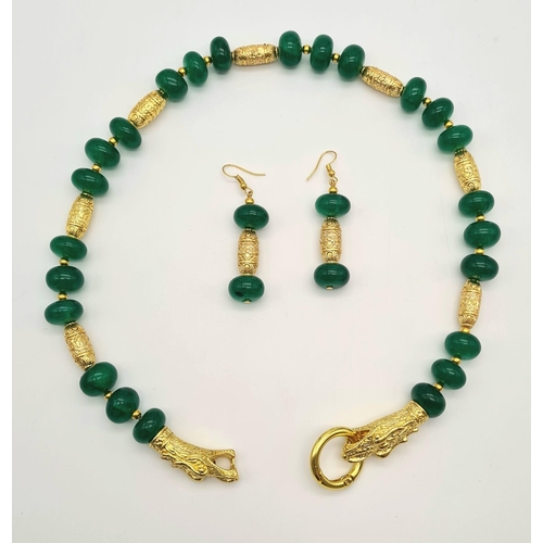 107 - A Chinese necklace and earrings set with large emerald cabochons and gold plated dragons, in a prese... 