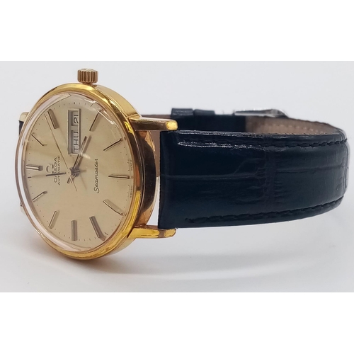 131 - A 1960s Omega Seamaster Gents Watch. Black leather strap and gold plated case - 35mm. Gold tone dial... 