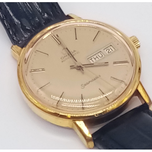 131 - A 1960s Omega Seamaster Gents Watch. Black leather strap and gold plated case - 35mm. Gold tone dial... 