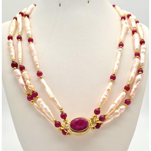 135 - A rarely seen, large Biwa pink pearls and round rubies three row necklace and earrings set in a pres... 