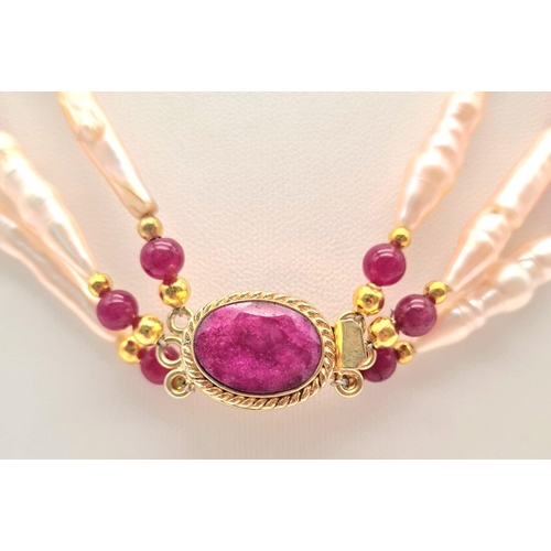 135 - A rarely seen, large Biwa pink pearls and round rubies three row necklace and earrings set in a pres... 