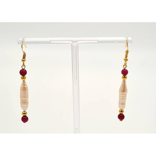 135 - A rarely seen, large Biwa pink pearls and round rubies three row necklace and earrings set in a pres... 