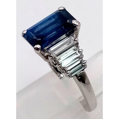 19 - A 14 K white gold ring with a beautiful emerald cut blue  sapphire (3 carats) and baguette diamonds ... 