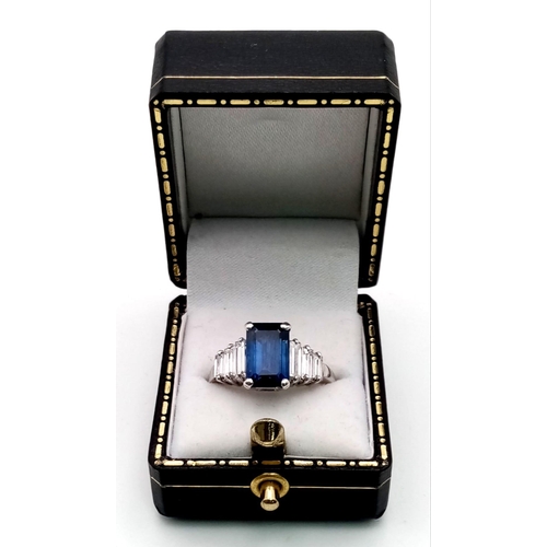 19 - A 14 K white gold ring with a beautiful emerald cut blue  sapphire (3 carats) and baguette diamonds ... 