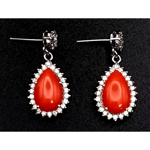 26 - A glamorous pair of 18ct white gold earrings with polished natural red coral and diamonds (1.5 carat... 