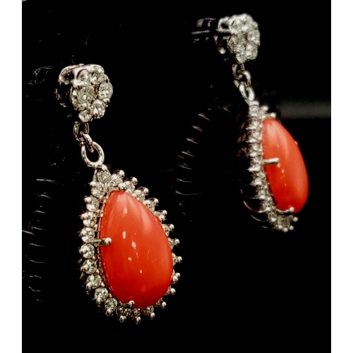 26 - A glamorous pair of 18ct white gold earrings with polished natural red coral and diamonds (1.5 carat... 