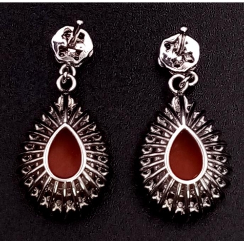 26 - A glamorous pair of 18ct white gold earrings with polished natural red coral and diamonds (1.5 carat... 