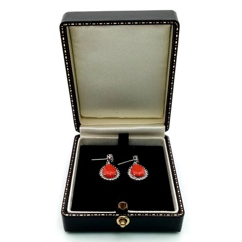 26 - A glamorous pair of 18ct white gold earrings with polished natural red coral and diamonds (1.5 carat... 