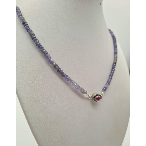 703 - Tanzanite Single Strand Necklace with Ruby Clasp in 925 Silver. 20.4 grams. Length: 48cm. Please see... 