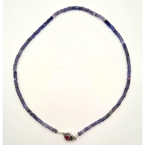 703 - Tanzanite Single Strand Necklace with Ruby Clasp in 925 Silver. 20.4 grams. Length: 48cm. Please see... 