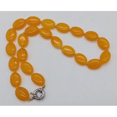 652 - A Yellow Jade Flat Bead Necklace. 15mm. 42cm.