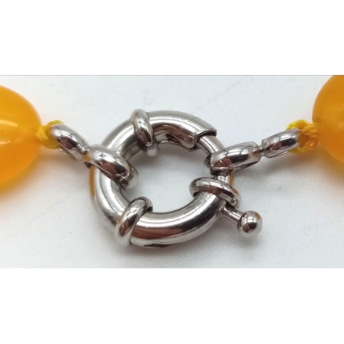 652 - A Yellow Jade Flat Bead Necklace. 15mm. 42cm.