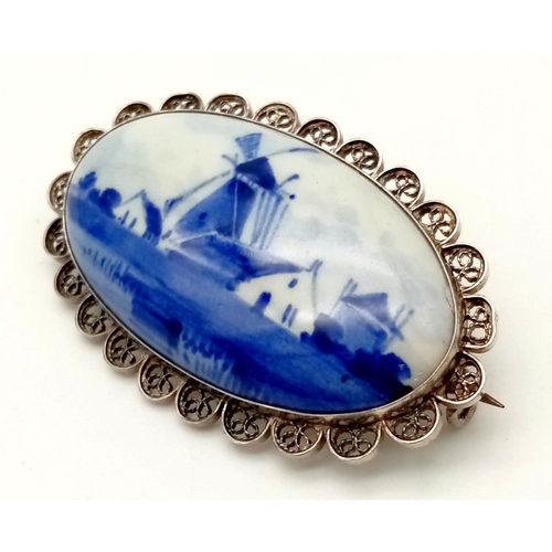 571 - An Antique Delft Ceramic Blue and White Brooch set in Silver. 5cm.