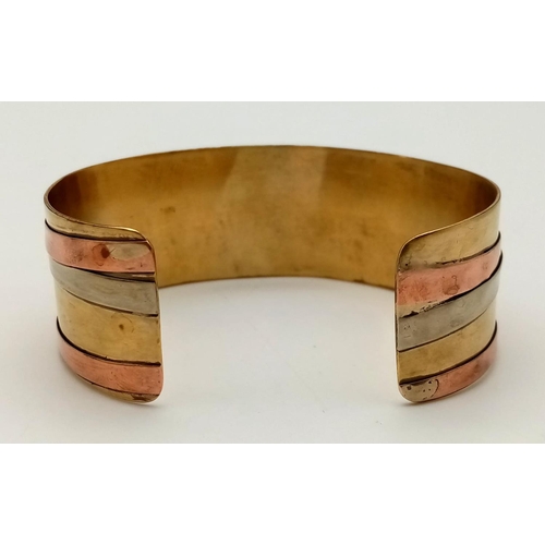 564 - A Wonder Woman-esque Three-Colour Open-Ended Gilded Bangle.