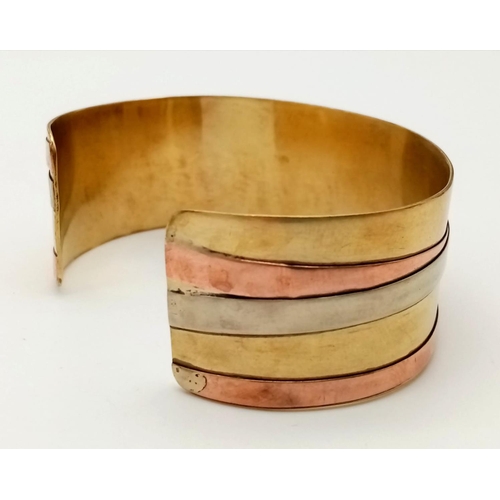 564 - A Wonder Woman-esque Three-Colour Open-Ended Gilded Bangle.