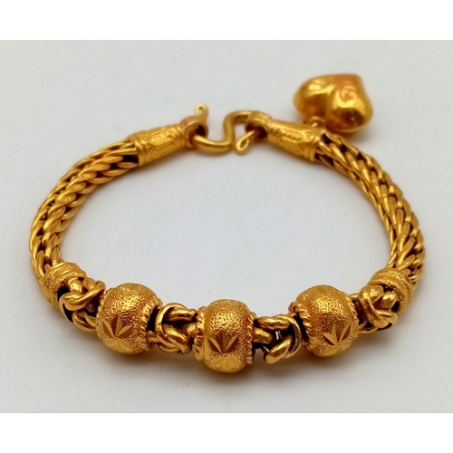 25 - A 22K Yellow Gold Asian Wedding Bracelet with Heart Charm. 17cm. 30.3g. Ref - 7477.