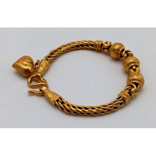 25 - A 22K Yellow Gold Asian Wedding Bracelet with Heart Charm. 17cm. 30.3g. Ref - 7477.