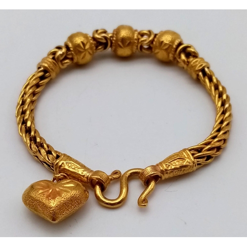 25 - A 22K Yellow Gold Asian Wedding Bracelet with Heart Charm. 17cm. 30.3g. Ref - 7477.