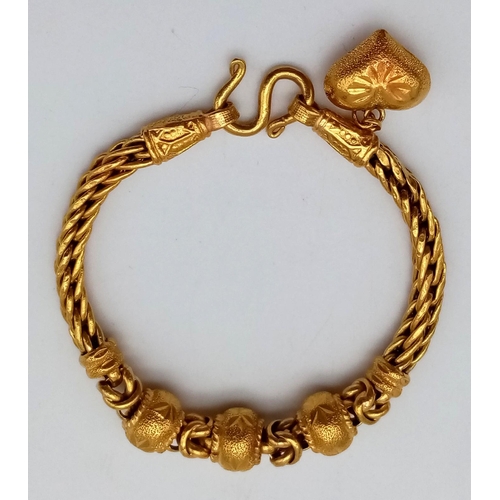 25 - A 22K Yellow Gold Asian Wedding Bracelet with Heart Charm. 17cm. 30.3g. Ref - 7477.