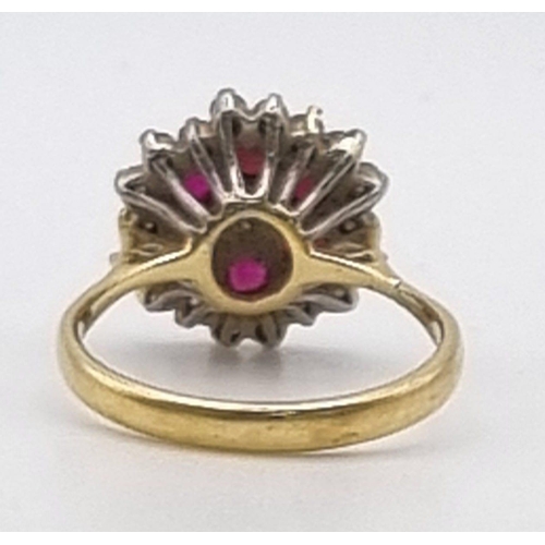 340 - An 18K Yellow Gold Ruby and Diamond Ring. Central diamond with ruby and diamond halos. Size P. 5.28g... 