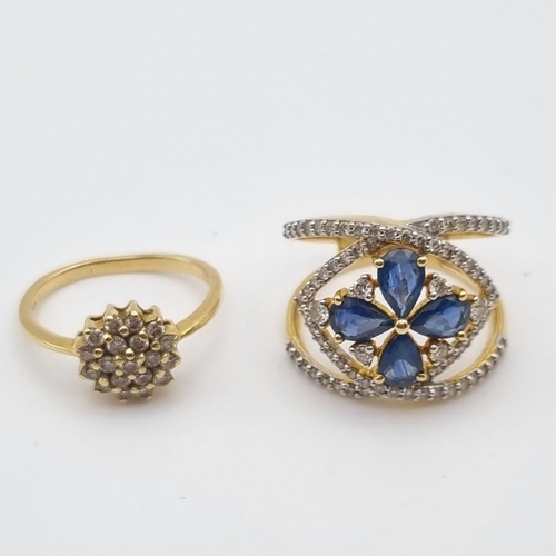 445 - Two 18K Yellow Gold Diamond Rings: A Crossover blue stones and diamond ring - size N and a floral sh... 