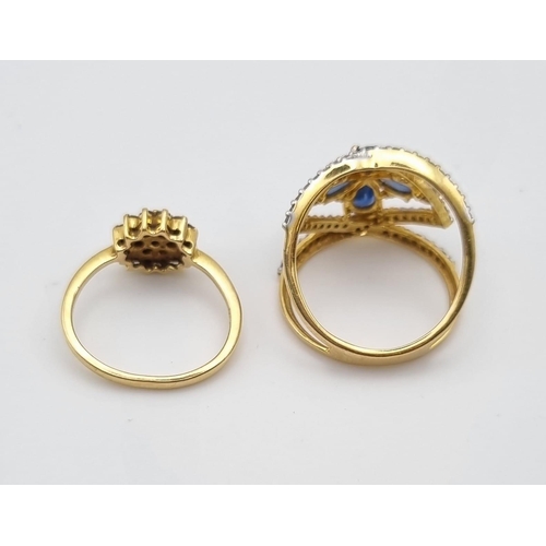 445 - Two 18K Yellow Gold Diamond Rings: A Crossover blue stones and diamond ring - size N and a floral sh... 