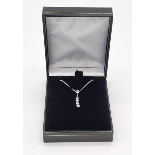 103 - An 18K White Gold Floating Graduated Diamond Pendant on an 18K White Gold Chain. 0.40ct of natural d... 