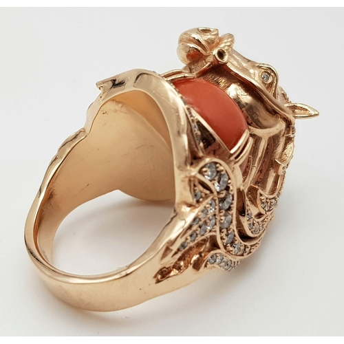 507 - An 18K Yellow Gold Natural Coral & Diamond Horse Figure Ring. 25.36g total weight. Size L 1/2.