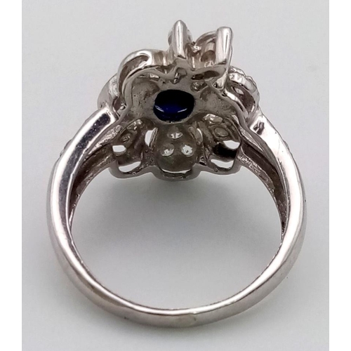 519 - 18K Gold Sapphire & Diamond Ring. Central sapphire surrounded by petals of diamonds. Size O. 5.32g t... 