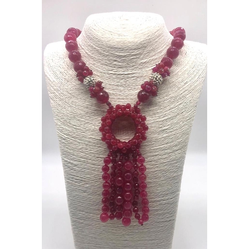 245 - A Faceted Fuchia-Pink Chalcedony Statement Necklace. Graduated beads leading to a large circular wre... 