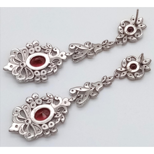 347 - 18K drop earrings garnets and diamonds. Length 17cm. 21.15 grams total.