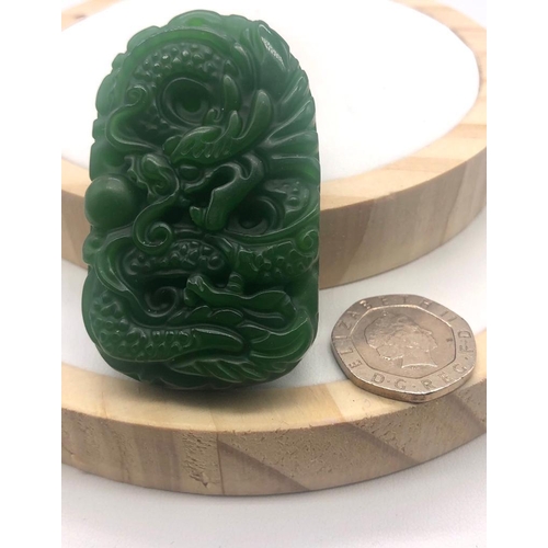 396 - A Green Jade Dragon-Image Carved Pendant. 5cm.