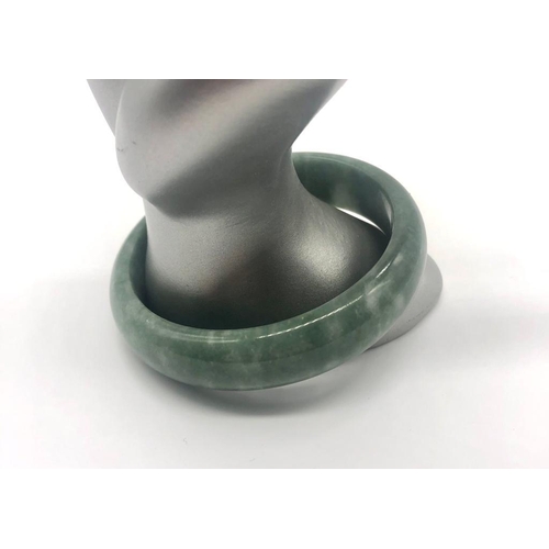 485 - A Green Jade Bangle (white swirls). 6cm inner diameter.