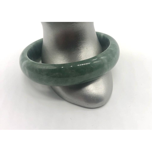 485 - A Green Jade Bangle (white swirls). 6cm inner diameter.