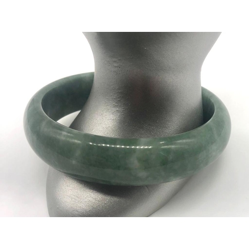 485 - A Green Jade Bangle (white swirls). 6cm inner diameter.