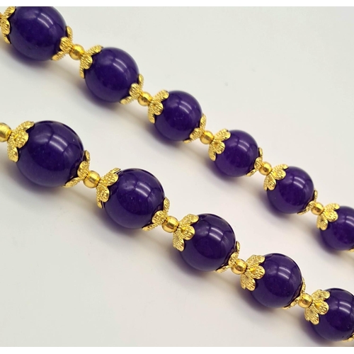 732 - A Purple Jade Beaded Necklace. Gilded spacers and clasp. Beads - 12mm. 44cm.