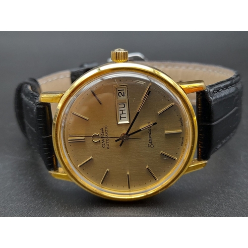 131 - A 1960s Omega Seamaster Gents Watch. Black leather strap and gold plated case - 35mm. Gold tone dial... 