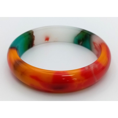 69 - A Wonderful Multi-Coloured Jade Bangle. Inner diameter
6.5cm.