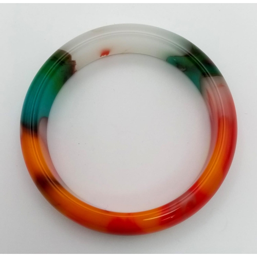 69 - A Wonderful Multi-Coloured Jade Bangle. Inner diameter
6.5cm.