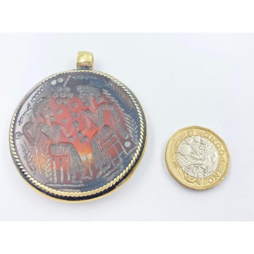 244 - An Ancient Hardstone Intaglio in a Yellow and White Metal Pendant Mount. 5cm diameter.