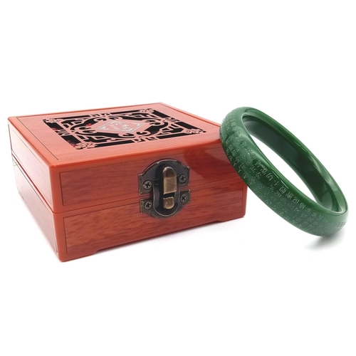 209 - A Tibetan, Buddhist, green jade bangle, with mantras engraved on the surface of the bangle. Internal... 