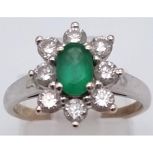 100 - An 18K White Gold Emerald and Diamond Ring. Central oval emerald - 0.5ct surrounded by eight petals ... 