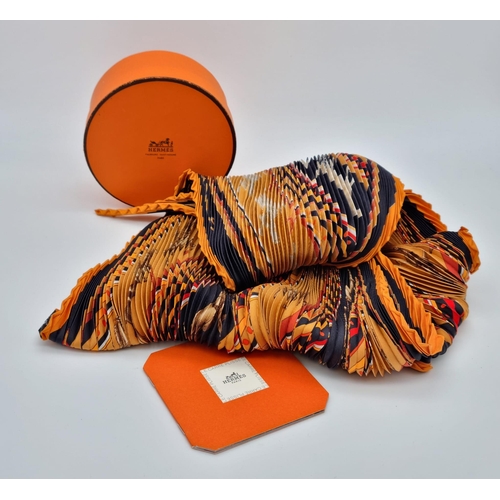 201 - A Hermes Black and Orange Plisse Scarf. In excellent condition - original box and booklet. Ref - 963... 