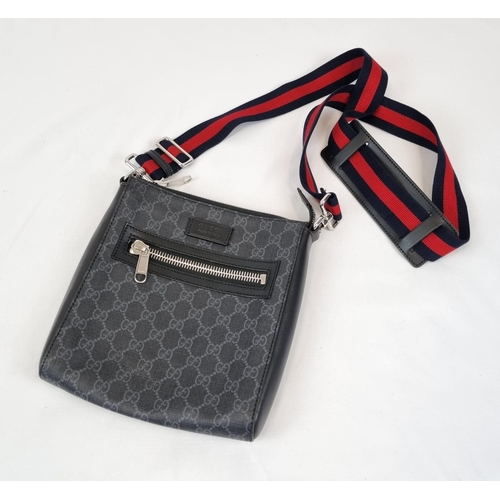 172 - A Black and Grey Gucci Supreme Messenger Bag. Monogrammed canvas exterior. Blue and red cloth strap.... 