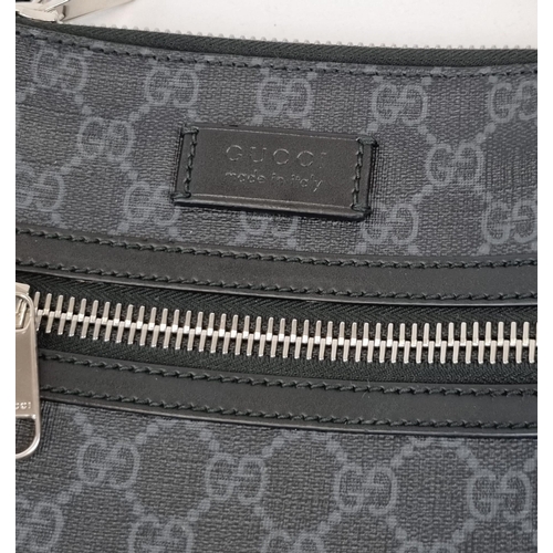 172 - A Black and Grey Gucci Supreme Messenger Bag. Monogrammed canvas exterior. Blue and red cloth strap.... 