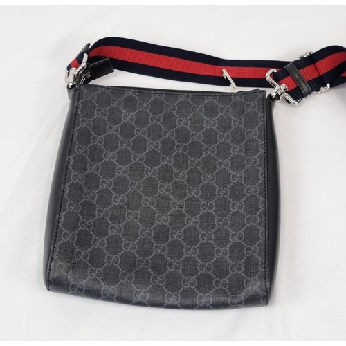 172 - A Black and Grey Gucci Supreme Messenger Bag. Monogrammed canvas exterior. Blue and red cloth strap.... 