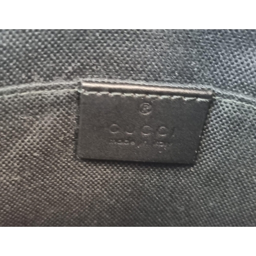 172 - A Black and Grey Gucci Supreme Messenger Bag. Monogrammed canvas exterior. Blue and red cloth strap.... 